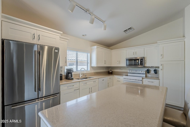 16523 W Desert Bloom St, Goodyear, AZ 85338 - kitchen featuring stainless steel appliances, white cabinets, lofted ceiling, a kitchen island, and track lighting