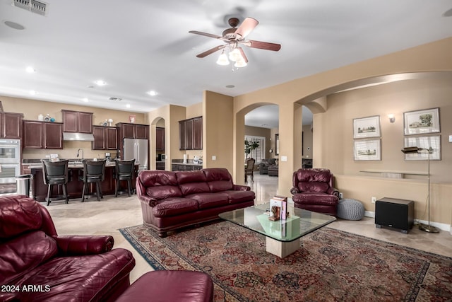 living room featuring ceiling fan and sink