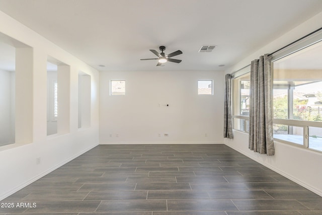 empty room featuring ceiling fan and a wealth of natural light