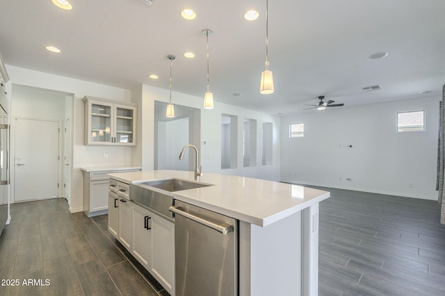 kitchen featuring dishwasher, ceiling fan, sink, white cabinets, and an island with sink