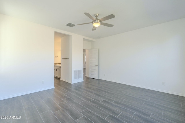 spare room with dark wood-type flooring and ceiling fan