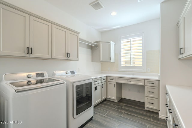 laundry area featuring separate washer and dryer, cabinets, and dark hardwood / wood-style flooring