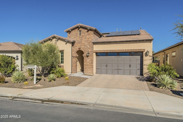 view of front of property with a garage and solar panels