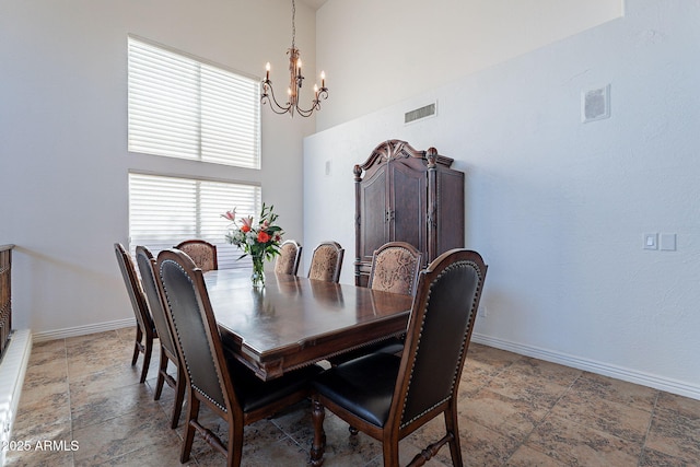 12925 W Llano Dr, Litchfield Park, AZ 85340 - dining area with a high ceiling, visible vents, baseboards, stone finish floor, and an inviting chandelier