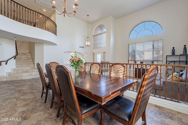 12925 W Llano Dr, Litchfield Park, AZ 85340 - dining space featuring a chandelier, a high ceiling, and stairs