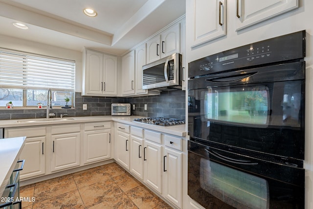 12925 W Llano Dr, Litchfield Park, AZ 85340 - kitchen with tasteful backsplash, white cabinets, appliances with stainless steel finishes, light countertops, and a sink