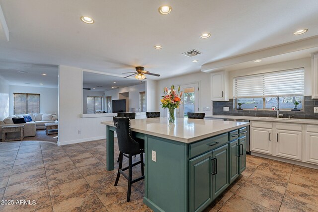12925 W Llano Dr, Litchfield Park, AZ 85340 - kitchen featuring open floor plan, a kitchen bar, a kitchen island, and white cabinets
