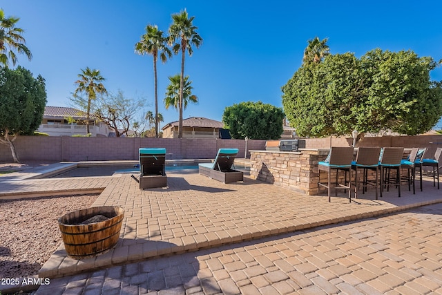 12925 W Llano Dr, Litchfield Park, AZ 85340 - view of patio / terrace with a fenced in pool, a fenced backyard, outdoor dry bar, and area for grilling