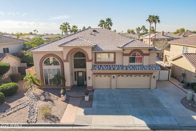 12925 W Llano Dr, Litchfield Park, AZ 85340 - mediterranean / spanish-style home with concrete driveway, a tile roof, an attached garage, fence, and stucco siding