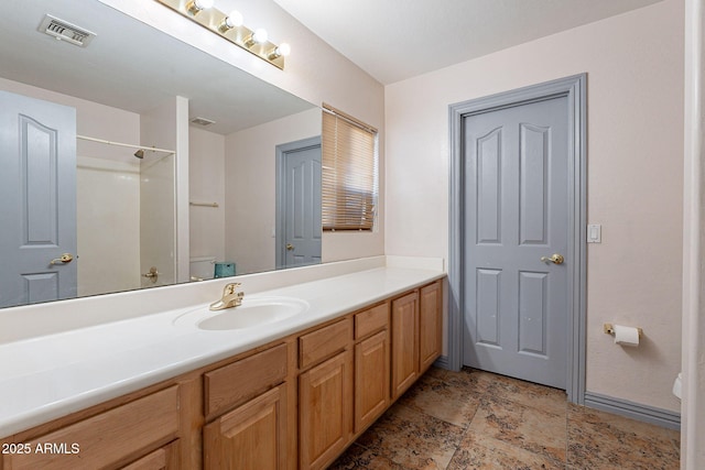 12925 W Llano Dr, Litchfield Park, AZ 85340 - full bath with visible vents, toilet, stone finish flooring, vanity, and walk in shower