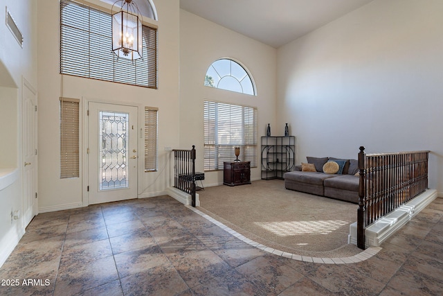 12925 W Llano Dr, Litchfield Park, AZ 85340 - carpeted entrance foyer with high vaulted ceiling, baseboards, and a chandelier