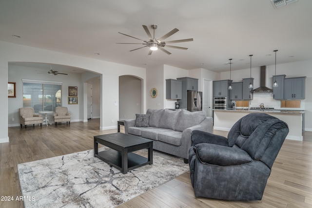 living room featuring light hardwood / wood-style flooring and ceiling fan