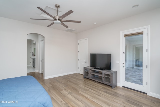 bedroom with ensuite bath, light wood-type flooring, and ceiling fan