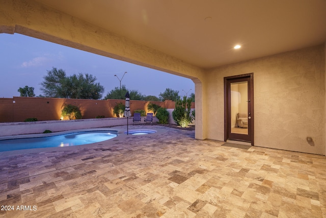 pool at dusk with a patio