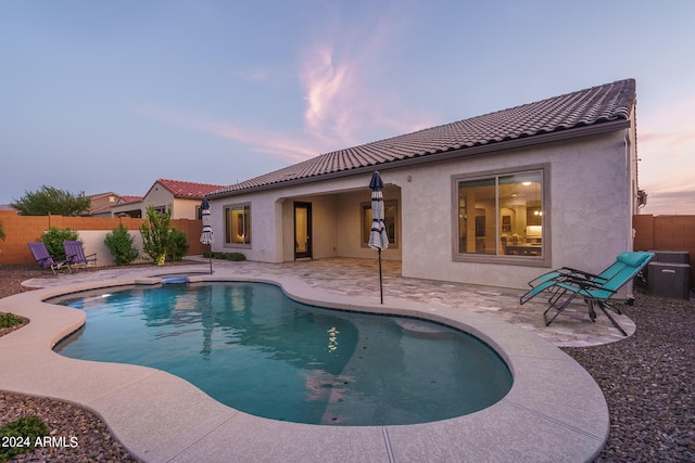 pool at dusk with a patio