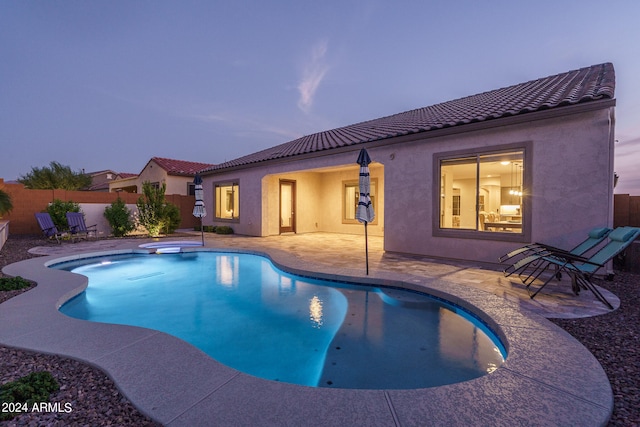 pool at dusk with a patio