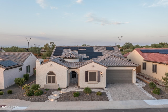 mediterranean / spanish home with a garage and solar panels