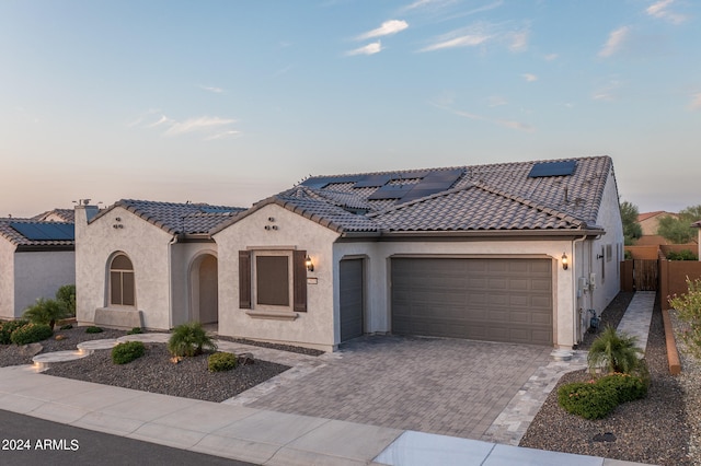 mediterranean / spanish home featuring a garage and solar panels