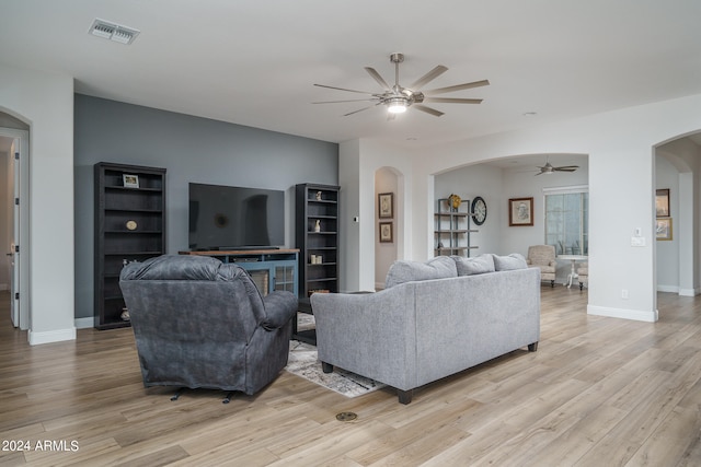 living room featuring a fireplace, light hardwood / wood-style flooring, and ceiling fan