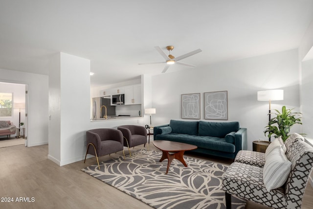 living room featuring ceiling fan and light hardwood / wood-style flooring