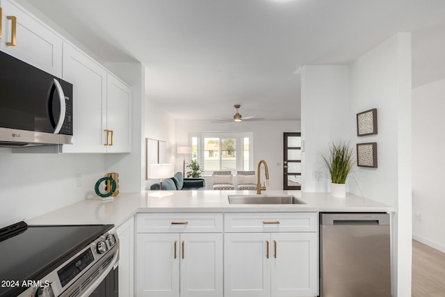 kitchen featuring kitchen peninsula, white cabinetry, sink, and appliances with stainless steel finishes