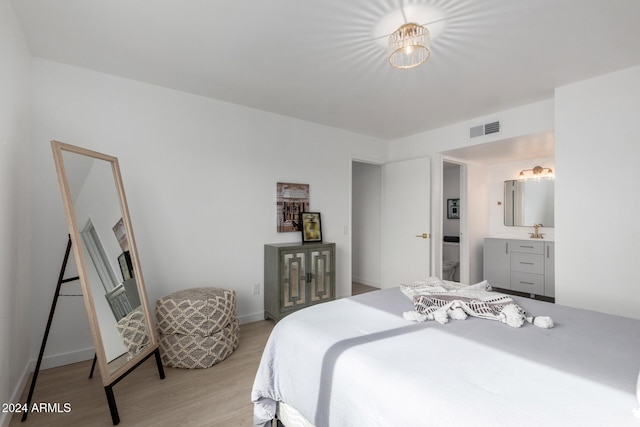 bedroom featuring light hardwood / wood-style flooring and sink