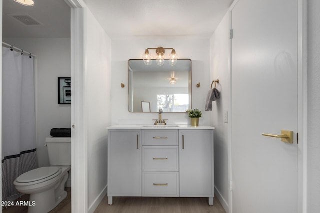 bathroom featuring walk in shower, hardwood / wood-style floors, vanity, and toilet