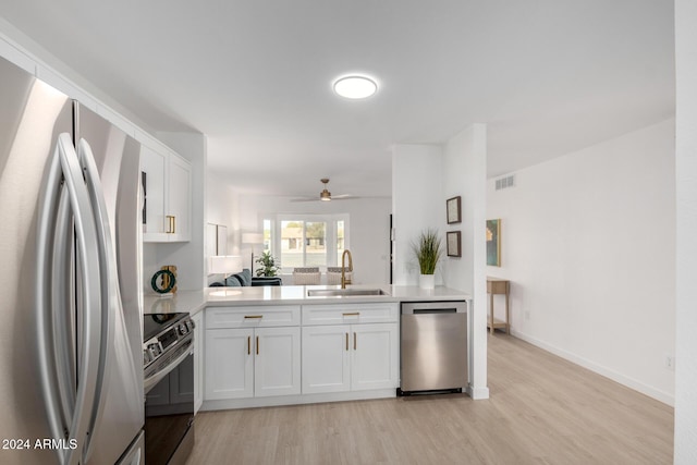 kitchen with stainless steel appliances, ceiling fan, sink, light hardwood / wood-style floors, and white cabinetry