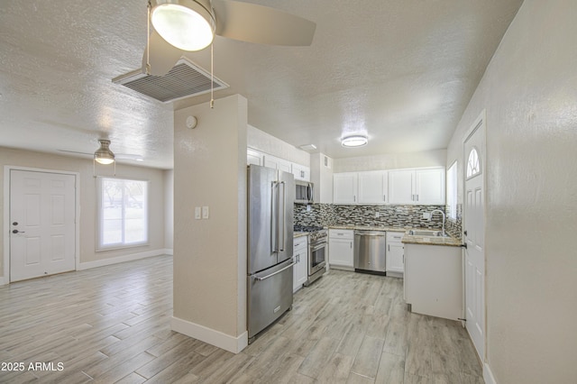 3408 W Virginia Ave, Phoenix, AZ 85009 - kitchen with premium appliances, ceiling fan, light wood-style flooring, a textured ceiling, and white cabinetry