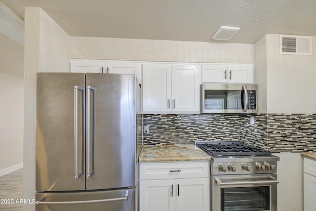 3408 W Virginia Ave, Phoenix, AZ 85009 - kitchen featuring high end appliances, white cabinetry, backsplash, and light stone counters