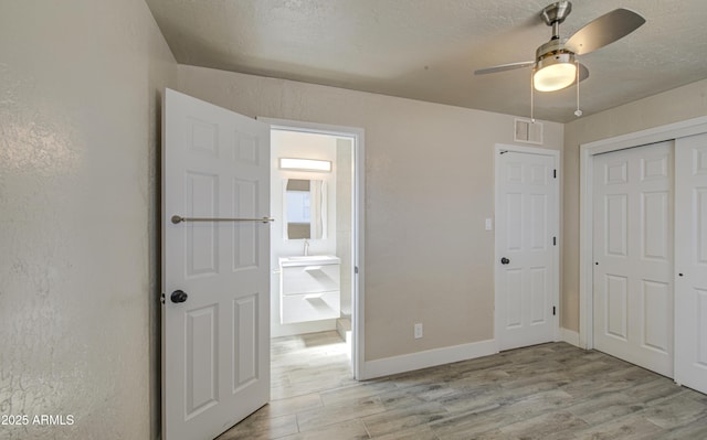 3408 W Virginia Ave, Phoenix, AZ 85009 - unfurnished bedroom featuring light wood-style floors, a closet, baseboards, and ensuite bath