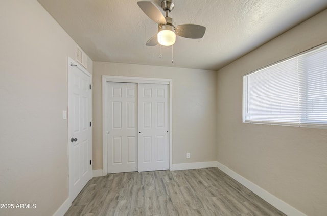3408 W Virginia Ave, Phoenix, AZ 85009 - unfurnished bedroom featuring light wood finished floors, a closet, a textured ceiling, baseboards, and a ceiling fan