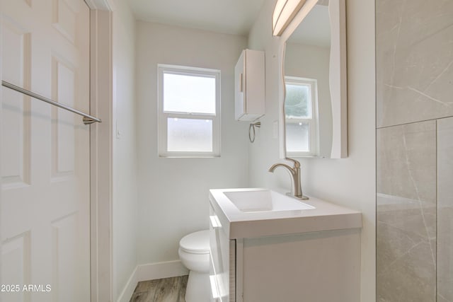 3408 W Virginia Ave, Phoenix, AZ 85009 - bathroom featuring toilet, vanity, wood finished floors, and baseboards