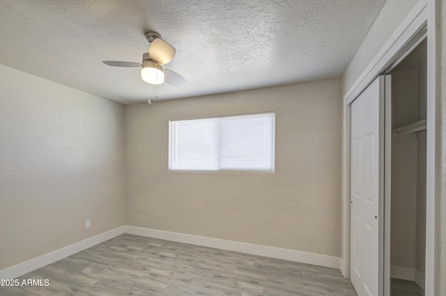 3408 W Virginia Ave, Phoenix, AZ 85009 - unfurnished bedroom with a closet, light wood-style flooring, a textured ceiling, baseboards, and ceiling fan