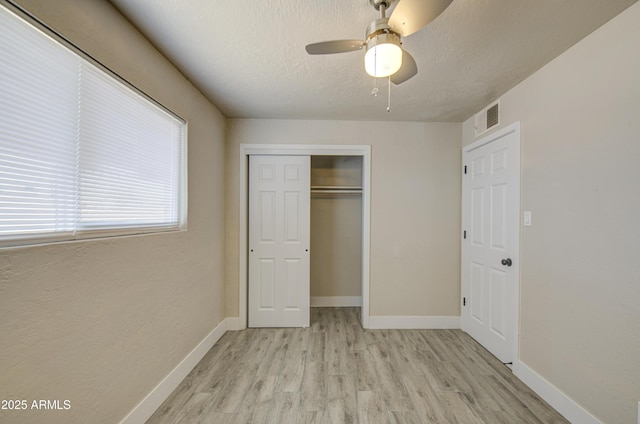 3408 W Virginia Ave, Phoenix, AZ 85009 - unfurnished bedroom featuring light wood-style flooring, a closet, baseboards, ceiling fan, and a textured ceiling