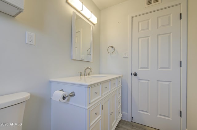 3408 W Virginia Ave, Phoenix, AZ 85009 - bathroom with toilet, vanity, and wood finished floors