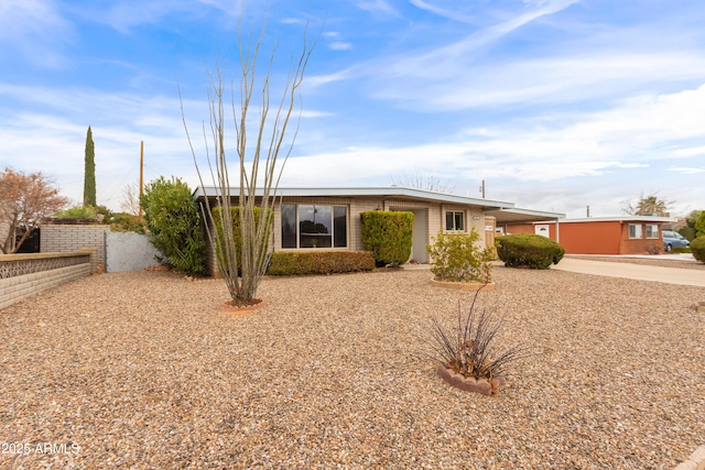 view of front of home featuring brick siding and fence