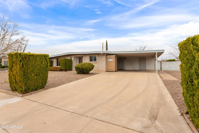 ranch-style house with a carport, fence, and driveway