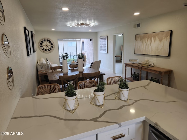 dining room featuring recessed lighting, visible vents, a textured wall, and a textured ceiling