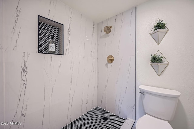 bathroom with a marble finish shower and toilet