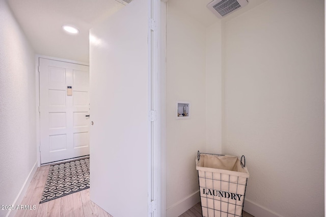 washroom featuring visible vents, washer hookup, wood finished floors, baseboards, and laundry area