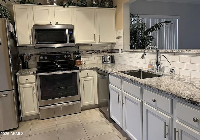 30178 N Coral Bean Dr, San Tan Valley, AZ 85143 - kitchen with appliances with stainless steel finishes, a sink, light stone counters, tasteful backsplash, and white cabinets