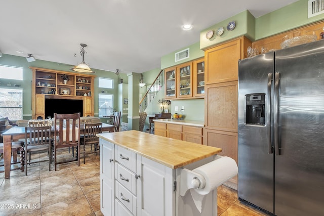 kitchen with glass insert cabinets, visible vents, plenty of natural light, and stainless steel fridge with ice dispenser