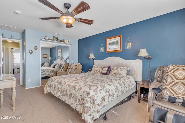 bedroom with carpet floors, ceiling fan, visible vents, and a closet