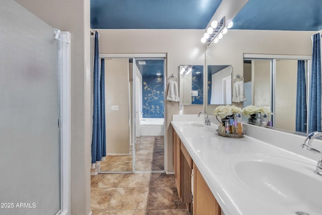 full bath featuring double vanity, a sink, a bathtub, and baseboards