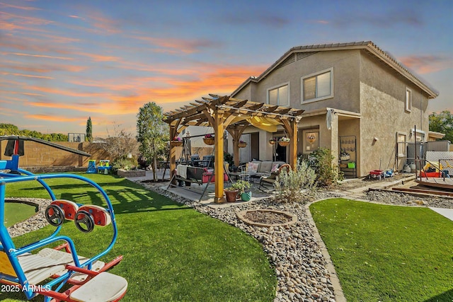 back of house featuring fence, a yard, stucco siding, a pergola, and a patio area