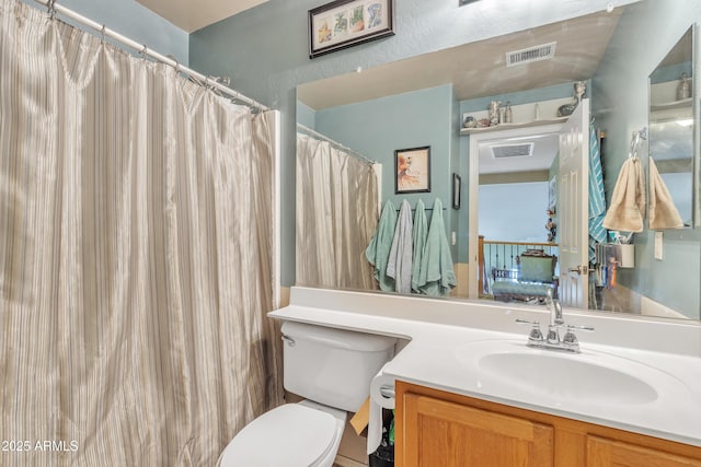 bathroom featuring toilet, visible vents, and vanity