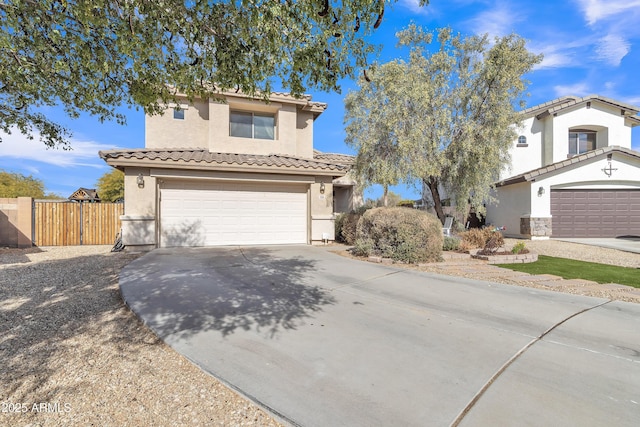 view of front of home with an attached garage, fence, driveway, a tiled roof, and stucco siding