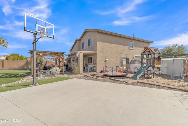 exterior space with basketball hoop, fence, a pergola, and a playground