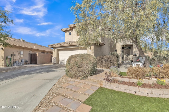 view of front of property with stucco siding, an attached garage, fence, driveway, and a tiled roof